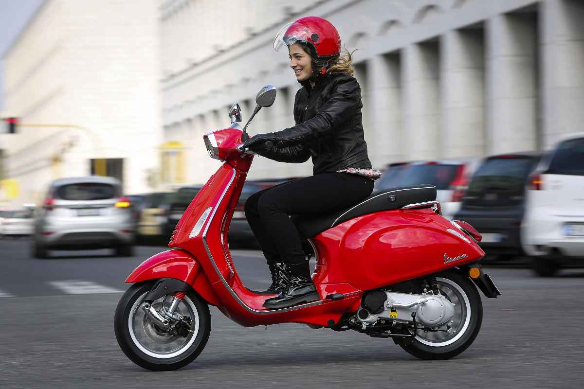 una ragazza alla guida della Vespa